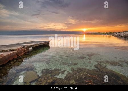 Ein Strand, der auf beiden Seiten vom Meer umgeben ist. Ein Holzsteg führt entlang des Sandstrandes in der Mitte. Naturschauspiel einer mediterranen Landschaft, Plaua edrijac, Nin, Zadar, Dalmatien, Kroatien Stockfoto