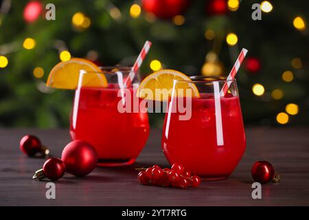 Weihnachtscocktail in Gläsern mit Zitrone und Johannisbeeren auf Holztisch, Nahaufnahme Stockfoto