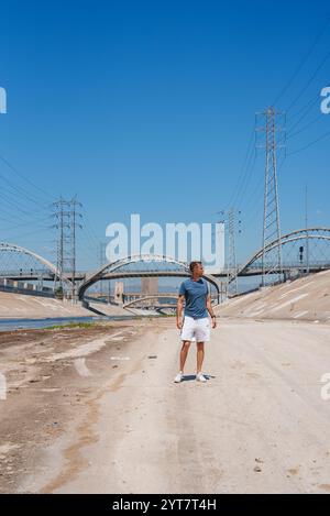 Person, die am Los Angeles River mit Sixth Street Viaduct steht Stockfoto