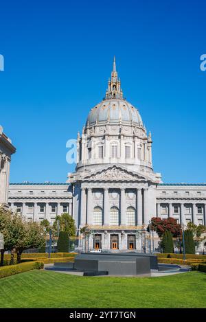 San Francisco City Hall mit seiner großen Beaux Arts Architektur und der hohen Kuppel. Ein gepflegter Garten und ein klarer blauer Himmel runden die Szene ab. Stockfoto