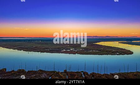 Der Sonnenaufgang über dem Horizont, während der Fluss vorbeifließt. Drohnenaufnahme bei Sonnenaufgang in Wilmington, NC Stockfoto