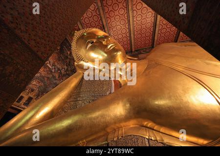 Eine Nahaufnahme des Kopfes der großen vergoldeten Statue des liegenden Buddha im Wat Pho (Tempel des liegenden Buddha) in Bangkok, Thailand Stockfoto