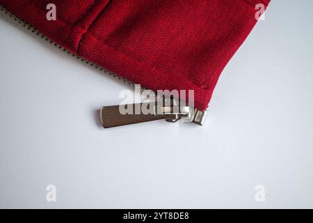 Nahaufnahme eines Reißverschlusses aus rotem Stoff mit Metallzug Stockfoto