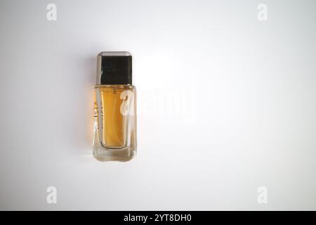 Minimalistische Parfümflasche mit schwarzer Kappe auf weißem Hintergrund Stockfoto