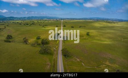 APRIL 2023, SANTA YNEZ, CA. - USA - California Oaks und State Highway auf grünem, grasbewachsenem Hügel außerhalb von Santa Ynez im Frühjahr Stockfoto