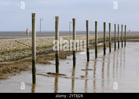 Deutschland, Niedersachsen, Juist, Ostfriesische Insel, Promenade und Holzpfähle am Hafen Stockfoto