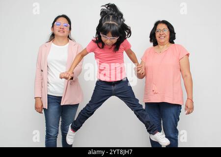 Die fünfjährige Lateinfrau erhält die Unterstützung ihrer dunkelhäutigen Mutter und Großmutter mit einer Brille für Pflege und Bildung Stockfoto