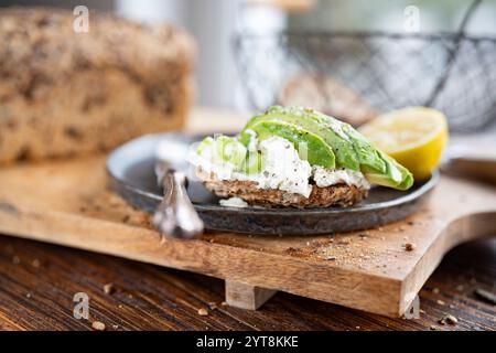 Frische Avocadoscheiben auf Getreidebrot mit Frischkäse Stockfoto