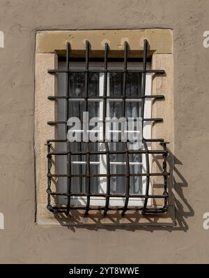 Sonniges, beleuchtetes Fenster an einer verputzten Wand Stockfoto