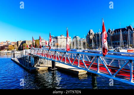 Eine Brücke über einem Gewässer mit rotem Geländer und Fahnen darauf. Die Fahnen sind rot und weiß und fliegen im Wind. Die Szene ist friedlich Stockfoto