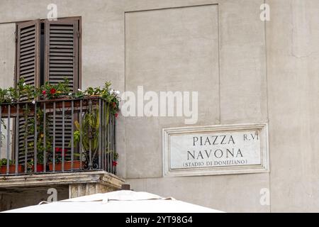 Ein Balkon mit Blumen neben dem Schild Piazza Navona im historischen Stadtzentrum von Rom, Italien Stockfoto