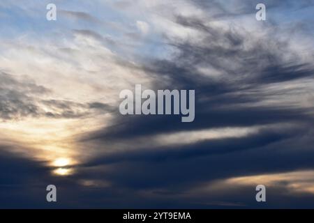 Abendsonne hinter grauen Schleierwolken Stockfoto