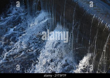 Sprudelndes Wasser auf einer Wehrwand Stockfoto