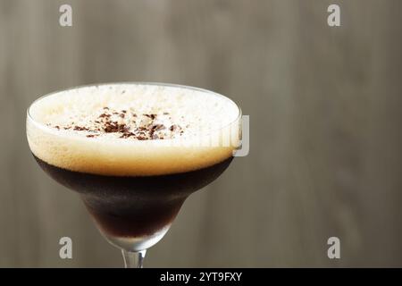 Köstlicher Espresso-Martini mit Kaffeebohnen im Glas auf verschwommenem Hintergrund, Nahaufnahme. Leerzeichen für Text Stockfoto