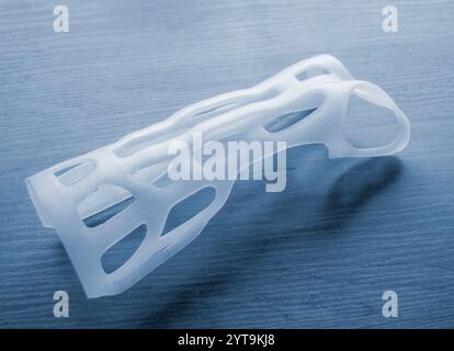 Handschienen-Korsett-Prothese auf 3D-Drucker aus geschmolzenem weißem Kunststoffpulver auf Tisch gedruckt. Kunststoffüberlagerung für Fixierer für medizinische Orthesen auf 3D-Drucker erstellt. Neue moderne medizinische 3D-Drucktechnologie Stockfoto