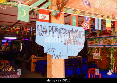 Ein Happy Menu, Happy Brownie Schild (Werbung für Gras, Cannabis) vor einer Bar (Jaidee Restaurant) in Vang Vieng, Nord-Laos, Südostasien Stockfoto