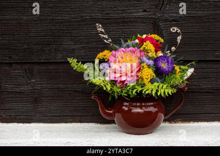 Herbstblumenstrauß in einem alten Emaille-Topf Stockfoto