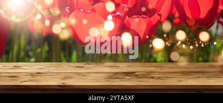 Rote Tulpen im Frühjahr mit Sun und Bokeh vor einem leeren Tisch für ein Konzept Stockfoto