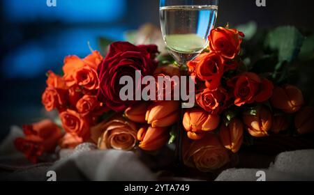 Großer Blumenstrauß in Rot mit Rosen und Champagner für Liebesgefühle. Romantischer Hintergrund für den Valentinstag oder den Muttertag. Stockfoto