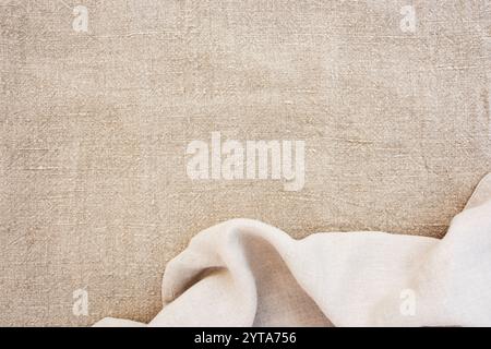 Helle Tischdecke aus Leinen mit Falten. Draufsicht auf Leinentextur. Hintergrund für Hochzeits- und Geburtstagsfeiern in natürlichem Boho-Stil mit Platz für Text. Stockfoto