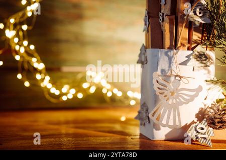 Adventskalender mit weihnachtslichtern auf rustikalem Holz. Handgefertigte, umweltfreundliche weihnachtsverpackung mit unscharfen Lichtern. Stockfoto