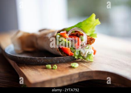 Tortilla-Wrap mit frischen Gemüse und gebratenem Hähnchenfleisch auf einem Teller. Hintergrundkonzept mit für gesunde Ernährung. Kurze Schärfentiefe. Stockfoto