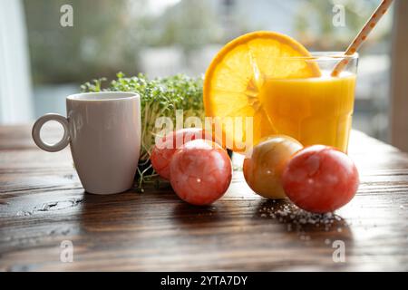 Gesunder ostersnack mit natürlichen Zutaten und frisch gepresstem Orangensaft und Espresso auf Holztisch. Stockfoto