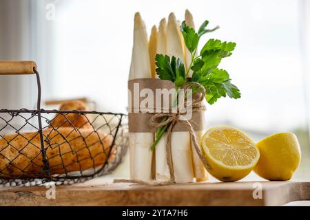 Frischer weißer Spargel und Kartoffeln. Frühlingsgemüse auf hölzernem Schneidebrett. Zutaten für ein gesundes Menü. Küche für die saisonale Gastronomie. Nahaufnahme mit kurzer Schärfentiefe. Stockfoto