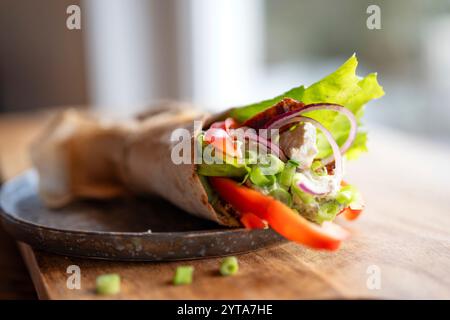 Tortilla-Wrap mit frischen Gemüse und gebratenem Hähnchenfleisch auf einem Teller. Hintergrundkonzept mit für gesunden Snack. Kurze Schärfentiefe. Stockfoto