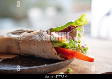 Tortilla-Wrap mit frischen Gemüse und gebratenem Hähnchenfleisch auf einem Teller. Hintergrundkonzept mit für gesunde Ernährung. Kurze Schärfentiefe. Stockfoto