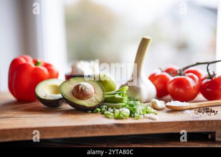 Gesundes Gemüse und frische Zutaten auf hölzernem Schneidebrett vor dem hellen Küchenfenster. Gesundes Nährstoffkonzept für eine Frühlingsdiät. Leerzeichen für Text. Stockfoto