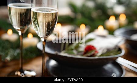 Zwei Gläser Sekt auf weihnachtlich dekoriertem Tisch vor einem festlichen Hintergrund mit kurzer Schärfentiefe. Stockfoto