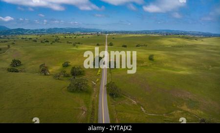 APRIL 2023, SANTA YNEZ, CA. - USA - California Oaks und State Highway auf grünem, grasbewachsenem Hügel außerhalb von Santa Ynez im Frühjahr Stockfoto