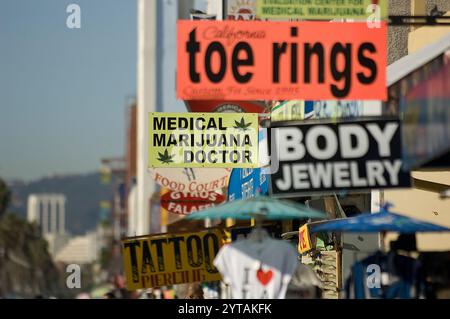 Helle Schilder für medizinische Marihuana-Kliniken säumen den lebhaften Venice Beach Bürgersteig und heben die Cannabiskultur und das Gesundheitswesen hervor. Stockfoto