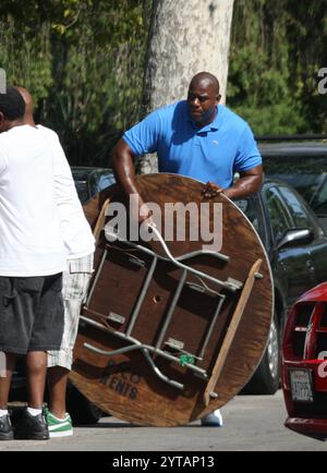 Magic Johnson nimmt an einer Community-Veranstaltung Teil, trägt Vorräte und richtet sich ein, zeigt sein Engagement für das Zurückgeben und inspirieren andere. Stockfoto