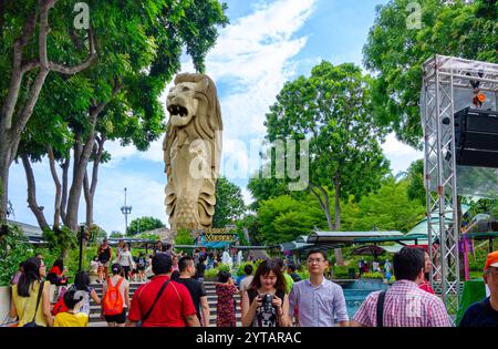 Besucher bewundern die majestätische Sentosa Merlion Statue inmitten des lebendigen Grüns und der lebhaften Atmosphäre auf Sentosa Island, Singapur. Stockfoto