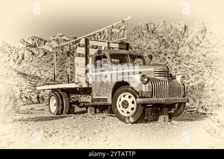 Ein alter Truck mit einem Coca-Cola-Schild an der Seite. Der Lkw steht auf einer Feldstraße in der Wüste Stockfoto