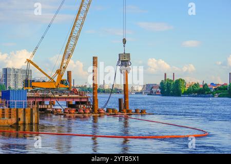 Kranbaubrücke. Montagehalterungen. Installation mit Vibrationsinstallation am Kran, die Säulen werden in Flussbett geschliffen. Auf Wasser Stockfoto