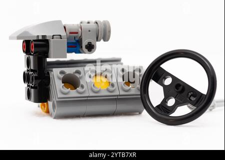 Ein Spielzeugmotor mit Lenkrad. Der Motor ist auf weißem Hintergrund Lego. Polen, Warschau 06.12.2024 Stockfoto