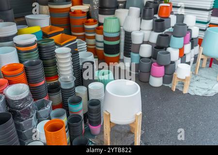 Viele Plastiktöpfe in verschiedenen Formen und Farben für den Anbau von Pflanzen auf der Theke in einem Gartengeschäft Stockfoto