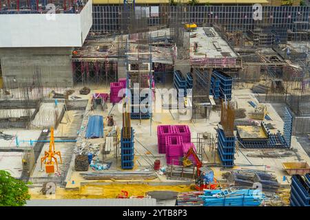 Bau des ersten Obergeschosses, Zementfundament, Stützen des zukünftigen Hochhauses, Installation eines Baukrans und Gießen von Flüssigzement. Stockfoto