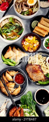 asiatische Gerichte und Snacks auf dunkelgrauem Hintergrund. Traditionelles kulinarisches Konzept. Draufsicht, flach, Kopierbereich Stockfoto