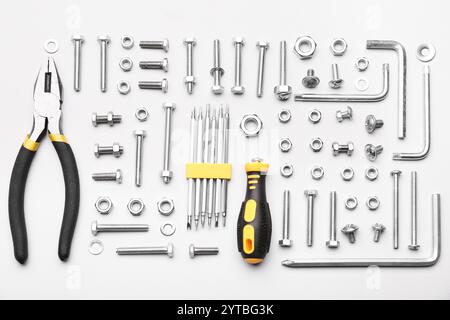 Anordnung verschiedener Gewindebolzen, Chrommuttern und Werkzeuge isoliert auf weißem Hintergrund Stockfoto