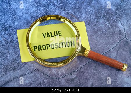 Business Planungs- und Analysenkonzept. WERTVERSPRECHEN FÜR Text, geschrieben durch eine Lupe, Draufsicht auf gelbem Papier. Stockfoto