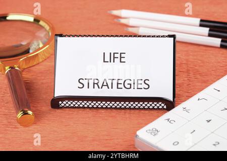 Geschäfts- und Technologiekonzept. Der Begriff LEBENSSTRATEGIEN auf einer Visitenkarte, die in einem Stand steht. Stockfoto