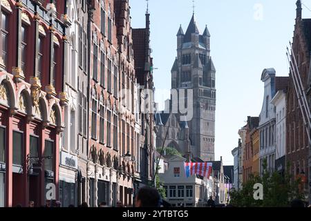 Steenstraat, die Haupteinkaufsstraße Brügge und der Turm im romanischen Wiedergeburtsstil mit romanischer und brabantischer Gotik Sint Salvatorskathedraal / Kathedrale Stockfoto