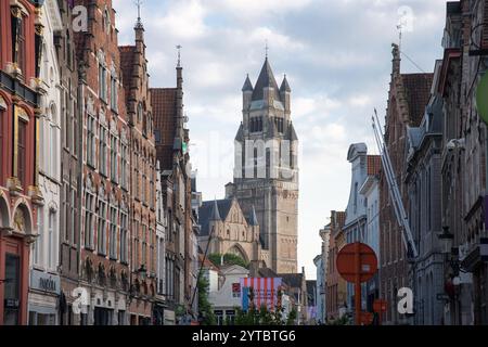 Steenstraat, die Haupteinkaufsstraße Brügge und der Turm im romanischen Wiedergeburtsstil mit romanischer und brabantischer Gotik Sint Salvatorskathedraal / Kathedrale Stockfoto