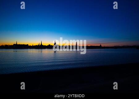 Eine wunderschöne Rigaer Stadtlandschaft während des farbenfrohen Sonnenaufgangs. Gebäude vor buntem Himmel. Nordeuropäischer Morgen mit warmem Himmel. Stockfoto