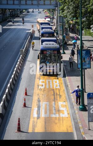 Bangkok, Thailand. Dezember 2024. Ein Blick auf eine Bushaltestelle mit einem Passagier, der einen kommenden Bus und ein Fahrrad auf der linken Seite eines Busses hält, in der Nähe des Eingangs zum Chatuchak Park in Bangkok. Der Chatuchak Park ist ein öffentlicher Park in Bangkok, der einen friedlichen Rückzugsort mit Grünflächen, einem See und Erholungsgebieten abseits der Hektik der Stadt bietet. Quelle: SOPA Images Limited/Alamy Live News Stockfoto