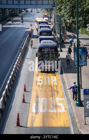 Bangkok, Thailand. Dezember 2024. Ein Blick auf eine Bushaltestelle mit einem Passagier, der einen kommenden Bus und ein Fahrrad auf der linken Seite eines Busses hält, in der Nähe des Eingangs zum Chatuchak Park in Bangkok. Der Chatuchak Park ist ein öffentlicher Park in Bangkok, der einen friedlichen Rückzugsort mit Grünflächen, einem See und Erholungsgebieten abseits der Hektik der Stadt bietet. (Foto: Nathalie Jamois/SOPA Images/SIPA USA) Credit: SIPA USA/Alamy Live News Stockfoto